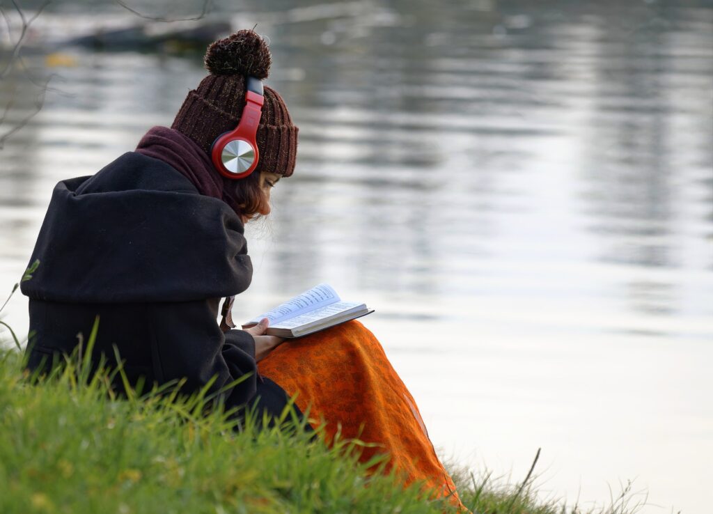 Come funziona l'audiolibro - Foto donna che legge e ascolta un libro